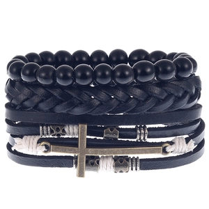 Detail of multi-layer men's leather bracelet with black beads and bronze cross charm