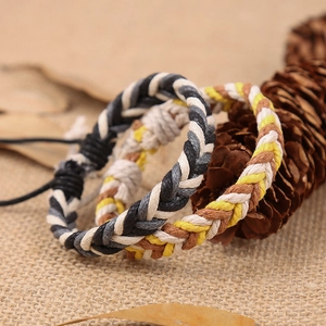 Detail van handgemaakte bohemien gevlochten armbanden met verstelbare knopen op rustieke stof