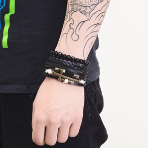 Detail view of multi-layer men's leather bracelet set with vintage metal cross charm
