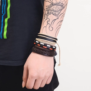 Close-up of multilayer men leather bracelets with anchor detail and braided textures