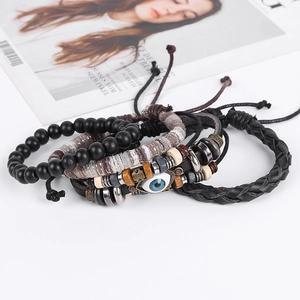 Détail d'un ensemble de bracelets ethniques en cuir avec perle mauvais œil et cordons tressés