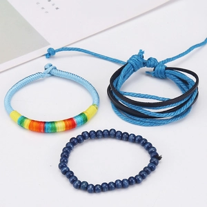 Close-up of three blue multilayered bracelets featuring leather, beads, and rainbow threads