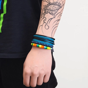 Detail of multi-layered braided leather bracelet with blue beads and colorful woven cords