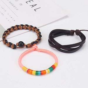 Detailed view of multilayer braided leather bracelets with nautical anchor charms in retro style