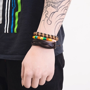Detail view of multi-layer braided leather bracelets on wrist featuring vintage nautical style