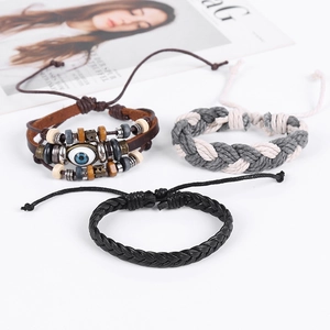 Three men's woven leather bracelets with evil eye bead and wooden accents on white background