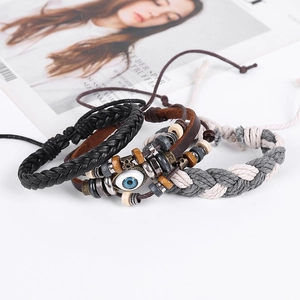 Close-up of four-piece men's leather bracelet set with beads and evil eye charm