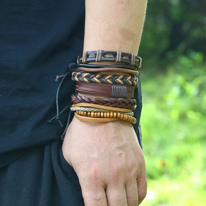 Macro detail of men's vintage multi-layer leather bracelets with wooden beads and woven straps