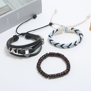 Macro detail of layered leather bracelet set with metallic charms and wooden beads