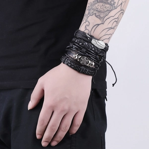 Men's multi-layer black leather bracelet set with silver wing and star charms on wrist