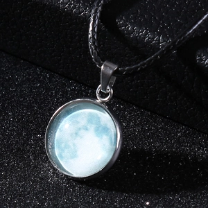 Macro shot of luminous moon pendant with black wax rope and silver alloy frame