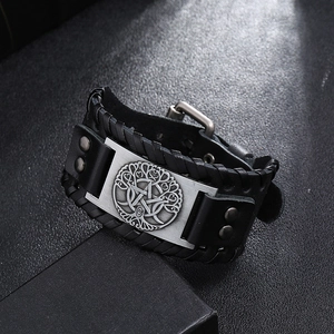 Close-up of vintage punk leather bracelet featuring tree of life metal plate and rivets
