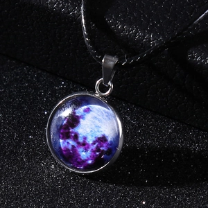 Macro shot of luminous nebula glass pendant with silver alloy frame on black cord