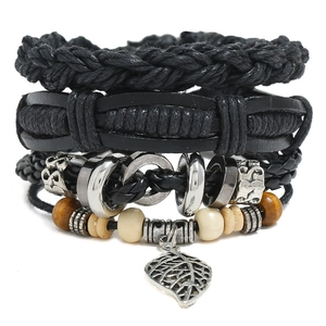 Detail of multi-layer black leather bracelet set with wooden beads and leaf pendant
