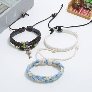 Detailed shot of multi-layer leather bracelets with beads, silver key charm and adjustable cords