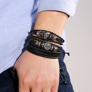 Men's retro layered leather bracelet with skull and pirate flag charms on braided rope