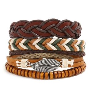 Detail of multi-layer leather bracelets with wooden beads and silver leaf charm