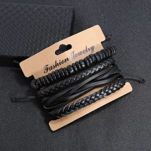 Set of four vintage braided leather bracelets in black with beads on a fashion display card