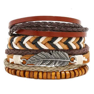 Detail view of multilayer braided leather bracelet set with vintage silver feather charm