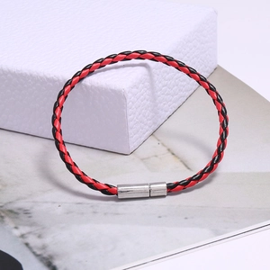 Détail du bracelet en cuir tressé rouge et noir avec un fermoir magnétique argenté
