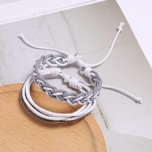Gros plan de bracelets en corde tissés à la main gris et blanc avec cordon réglable