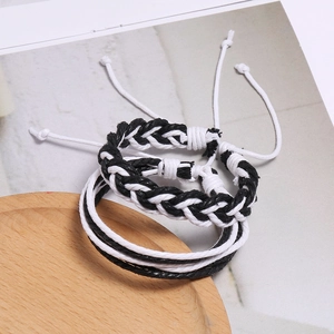 Détail de deux bracelets tressés à la main noir et blanc avec nœuds coulissants réglables