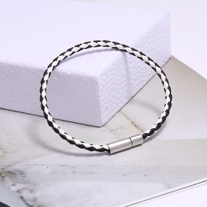 Détail du bracelet tressé noir et blanc avec fermoir magnétique cylindrique en argent