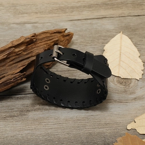 Macro-opname van zwarte leren band met metalen gesp en vintage stiksels op de pols