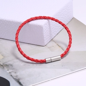 Détail du bracelet tressé rouge en cuir avec fermoir magnétique cylindrique argenté