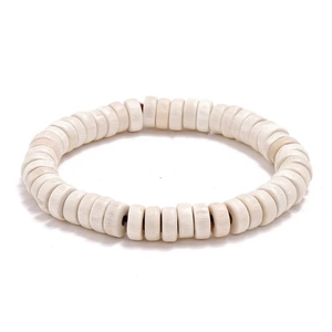 Detailed macro view of white Heishi wood beads with natural texture on an elastic bracelet
