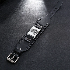 Detail of Nordic wolf head engraving on a wide black leather punk style bracelet