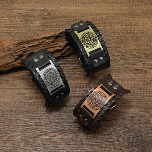 Detailopname van de Noordse Viking kompas lederen armbanden op een houten ondergrond