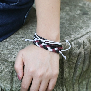 Détail d'un bracelet tissé fait main avec des cordons multicouches noirs et rouges
