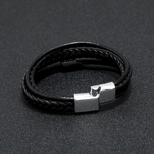 Multilayer braided leather bracelet for men with silver magnetic buckle on dark background