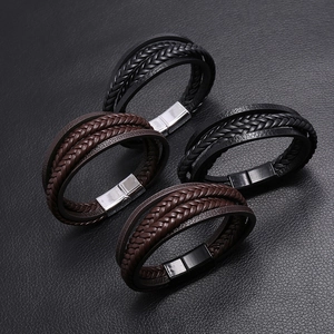 Detail of multi-layered braided leather bracelets with brushed magnetic metal clasps