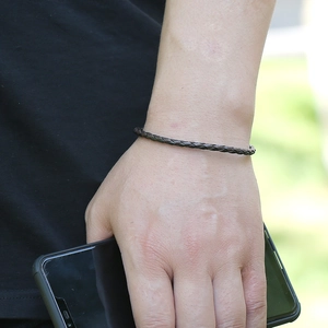 Bracelet minimaliste en cuir tressé marron foncé pour couples porté au poignet