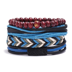 Gros plan de bracelets multicouches en cuir vintage avec cordons et perles en bois rouge