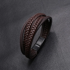 Detail view of multi-layer brown braided leather bracelet with black magnetic metal clasp