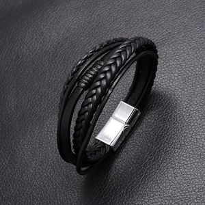 Close-up of multilayer black leather bracelet with silver magnetic buckle and braided cords
