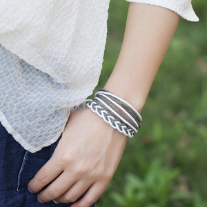 Ensemble de bracelets tressés à la main en vert et blanc sur le poignet d'un modèle