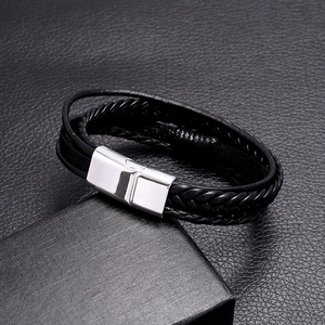 Macro detail of multi-layer woven black leather bracelet with silver magnetic alloy clasp