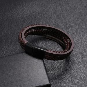 Macro shot of multi-layer brown woven leather bracelet with matte black magnetic buckle