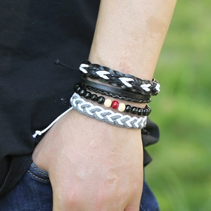 Vue détaillée de bracelets multicouches en cuir tressé rétro et perles sur un poignet homme