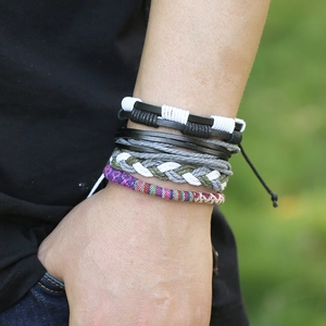 Détail de bracelets multicouches en cuir tressé et cordes ethniques sur un poignet homme