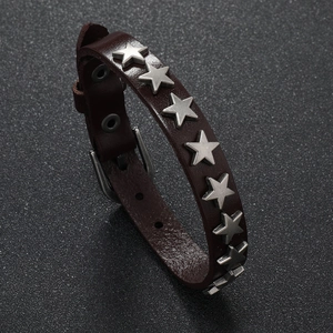 Close-up of vintage brown leather punk bracelet with seven silver metallic star studs