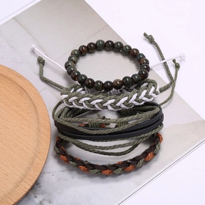 Détail d'un lot de quatre bracelets vintage en cuir tissé avec perles œil de tigre et cordes