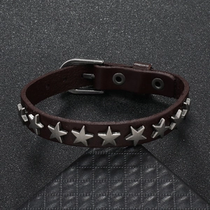 Close-up of punk style dark brown leather bracelet with silver star metal studs and buckle