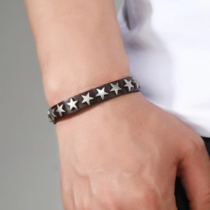 Close-up of a punk style dark brown leather bracelet with silver star metal rivets