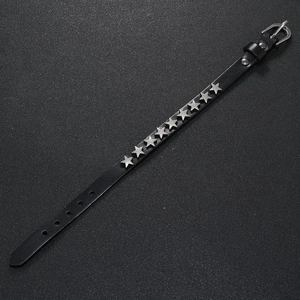 Detail of black leather punk bracelet with silver star rivets and buckle fastener