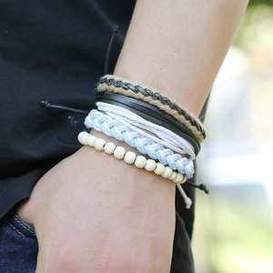 Gros plan de bracelets multicouches en cuir et corde tressée au poignet style rétro
